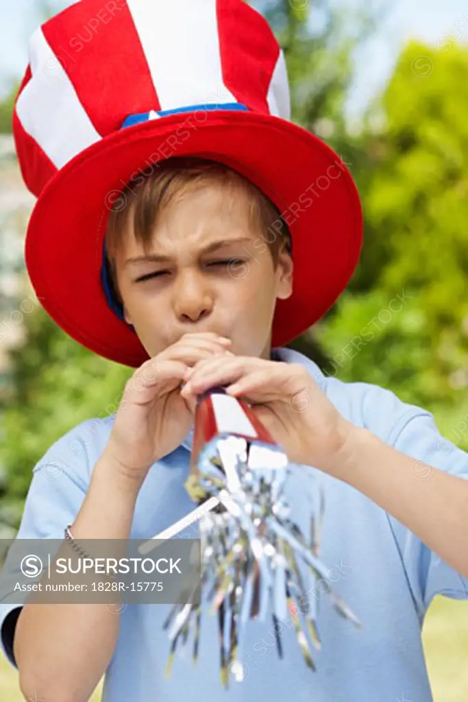 Portrait of Boy Wearing Large Hat and Blowing Noisemaker Horn   
