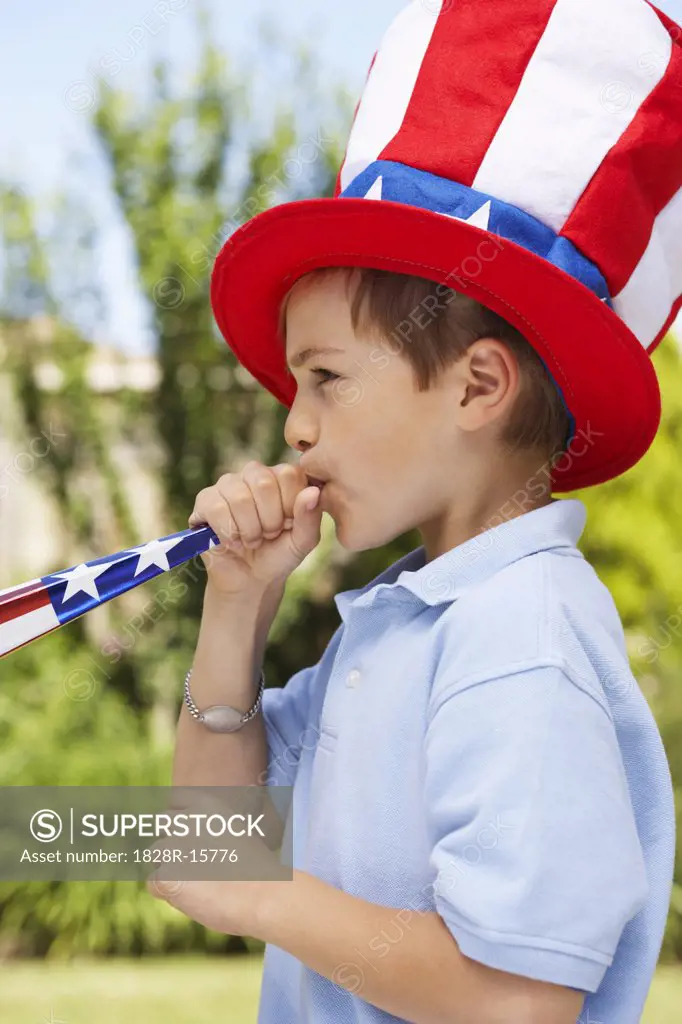 Portrait of Boy Wearing Large Stars and Stripes Hat, Blowing Noisemaker Horn   