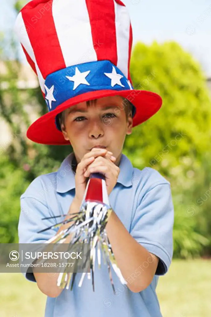 Portrait of Boy Wearing Large Stars and Stripes Hat, Blowing Noisemaker Horn   