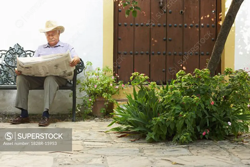 Man Reading Newspaper Outdoors   