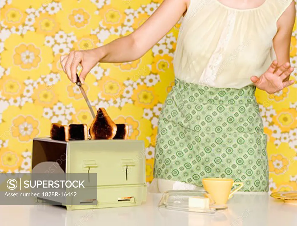 Woman Removing Burnt Toast from Toaster   