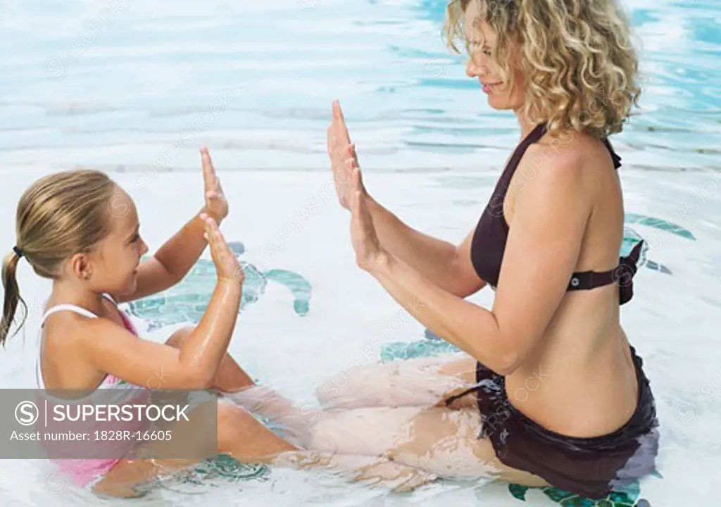 Mother and Daughter Playing in Swimming Pool   