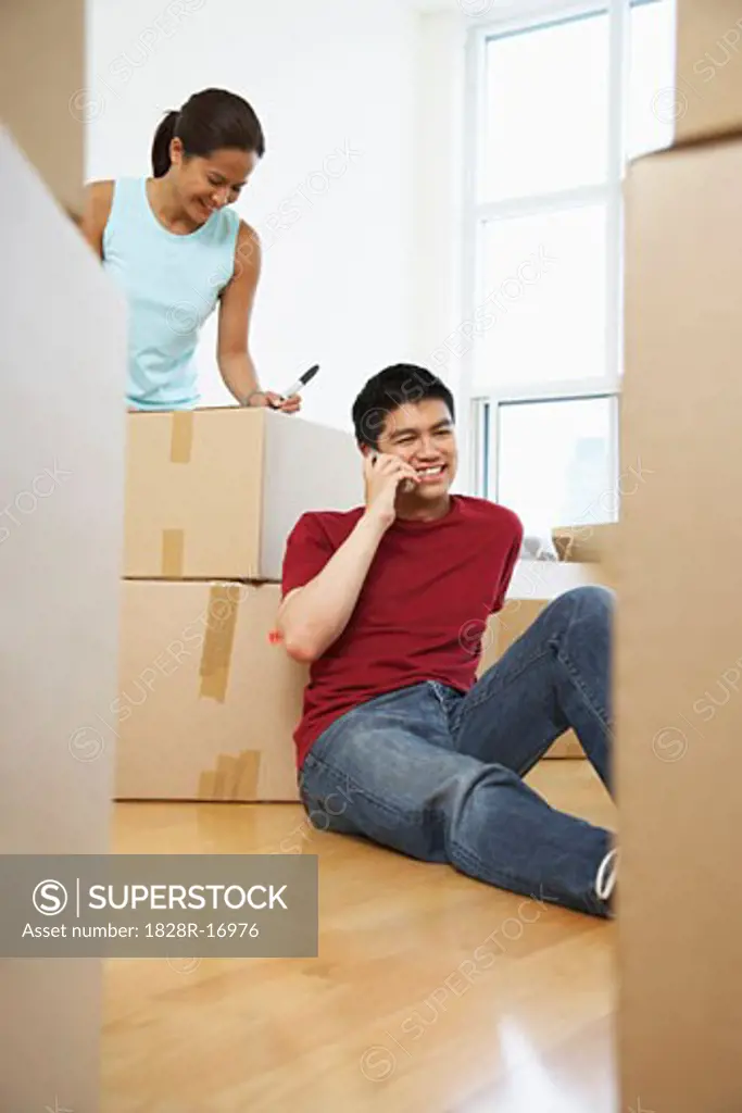Woman Packing, Man on Cellular Phone   