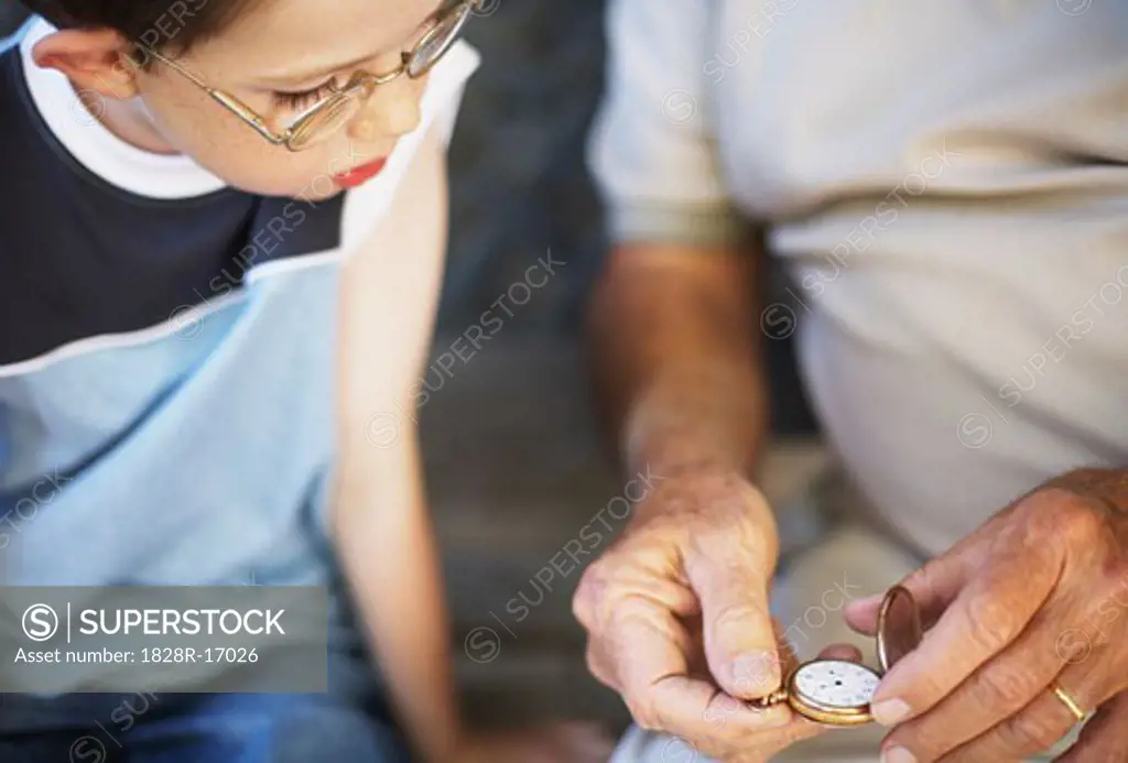 Boy Looking at Man's Pocket Watch   