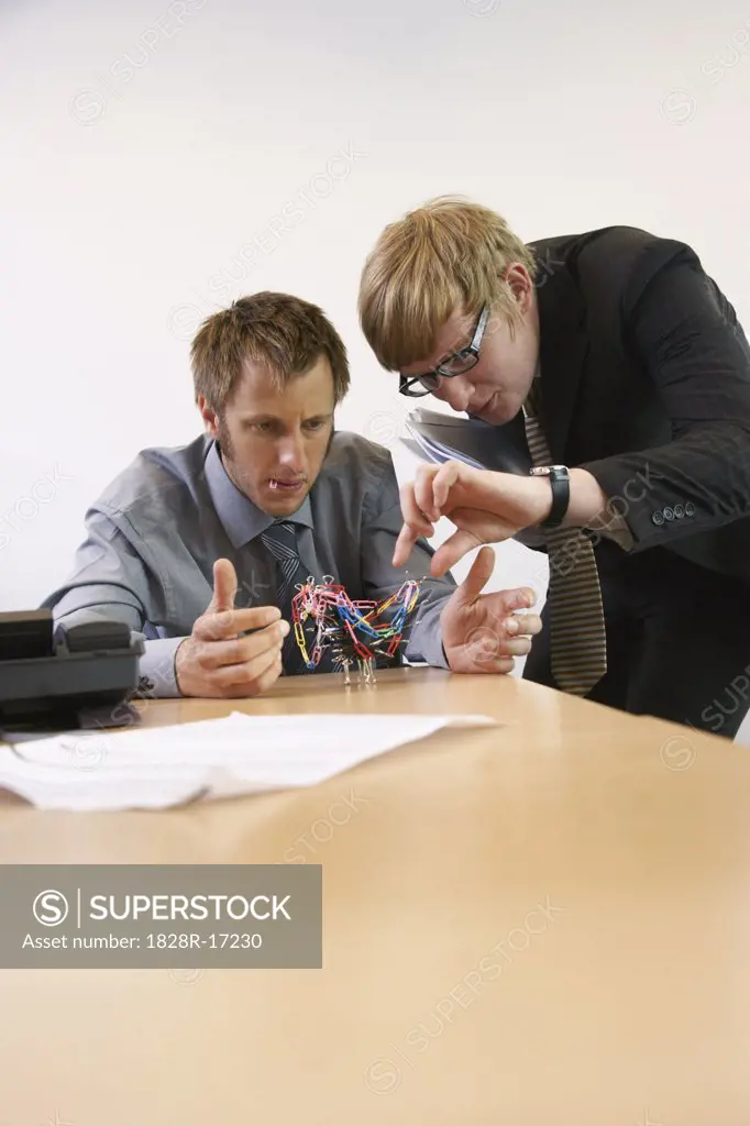 Businessmen Playing with Paperclips   