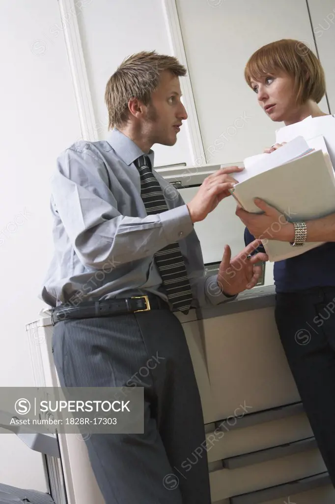 Office Workers Talking by Photocopier   