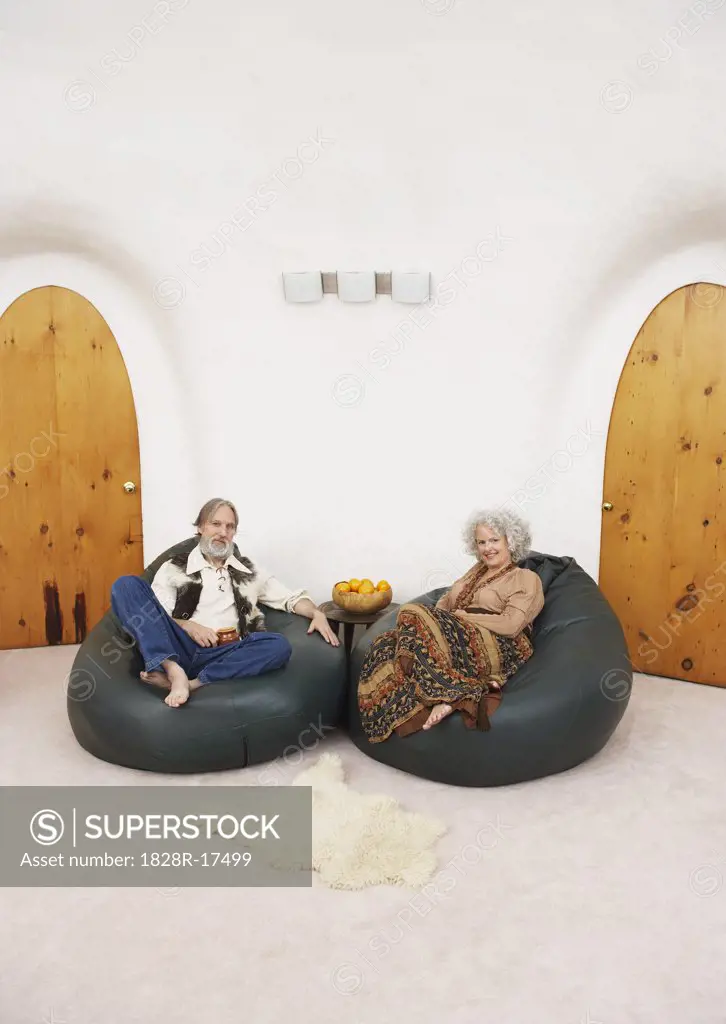 Couple Sitting in Bean Bag Chairs in Living Room   