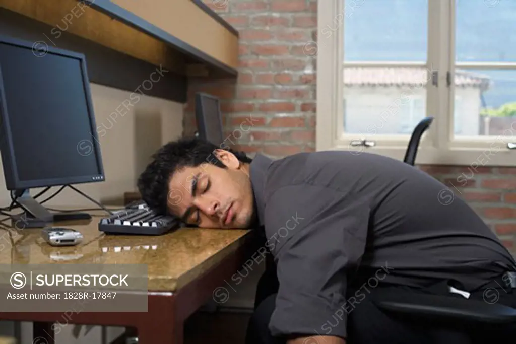 Businessman Asleep at Desk   