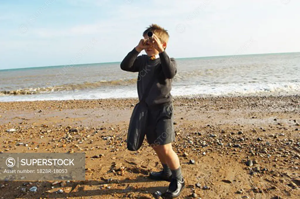 Boy Using Telescope at the Beach   