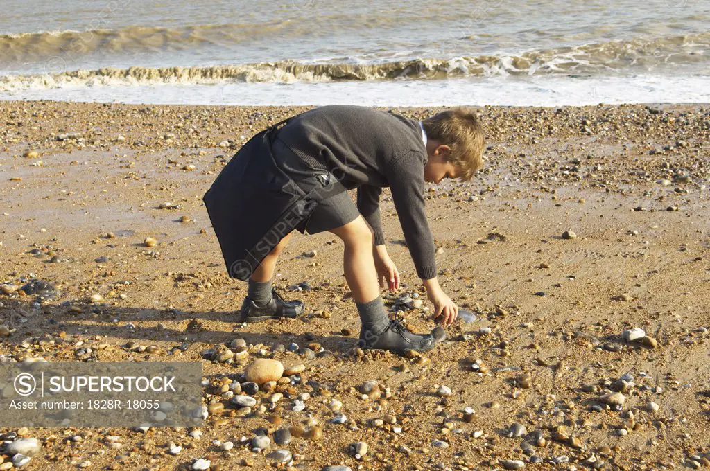 Boy Picking Up Rocks at the Beach   