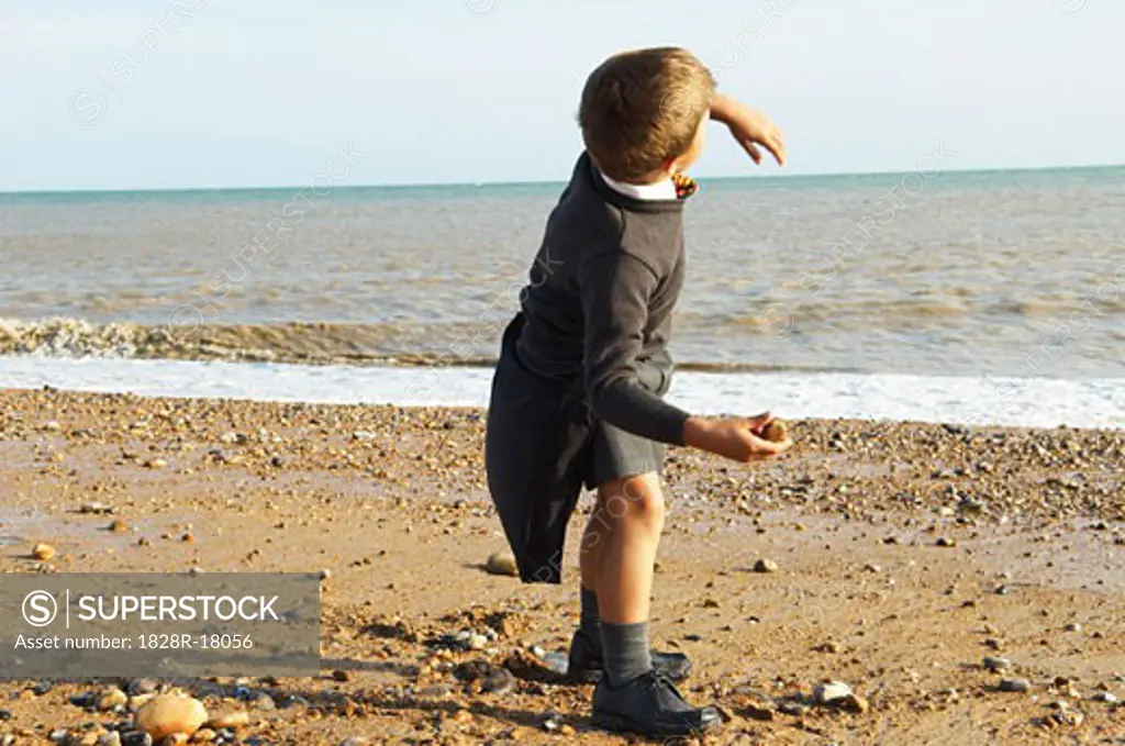 Boy Throwing Rocks at the Beach   