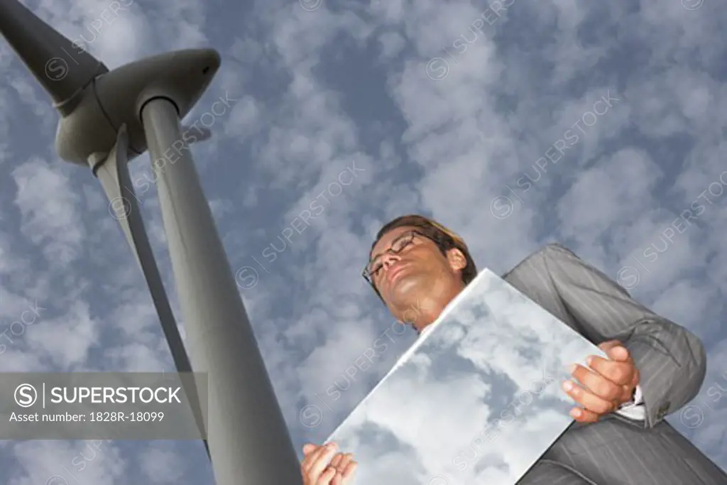 Businessman with Mirror by Wind Turbine   