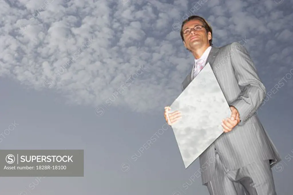 Businessman Reflecting Sky in Mirror   