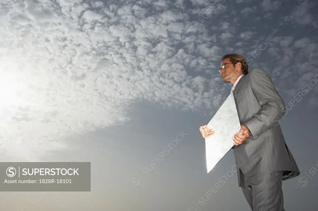 Businessman Reflecting Sky in Mirror   