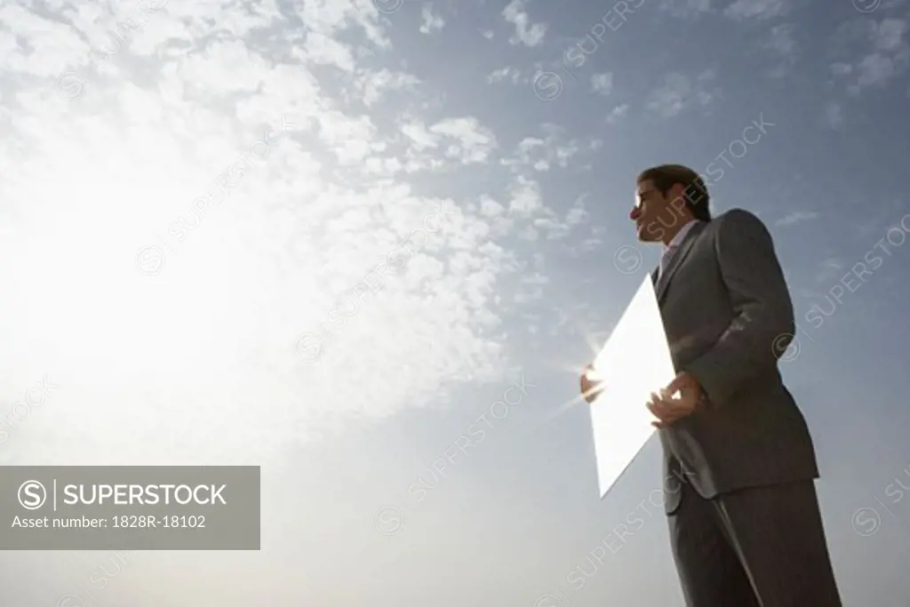 Businessman Reflecting Sky in Mirror   