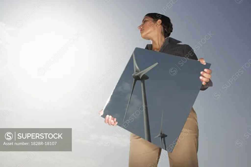 Woman Reflecting Wind Turbines in Mirror   