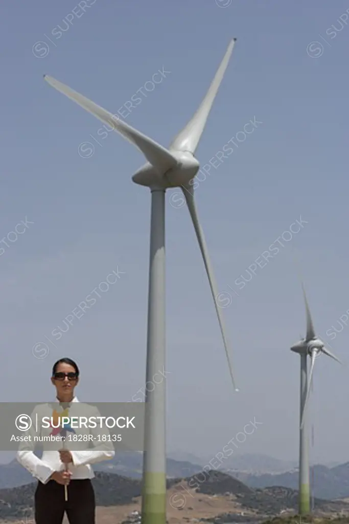 Businesswoman with Pinwheel by Wind Turbine   