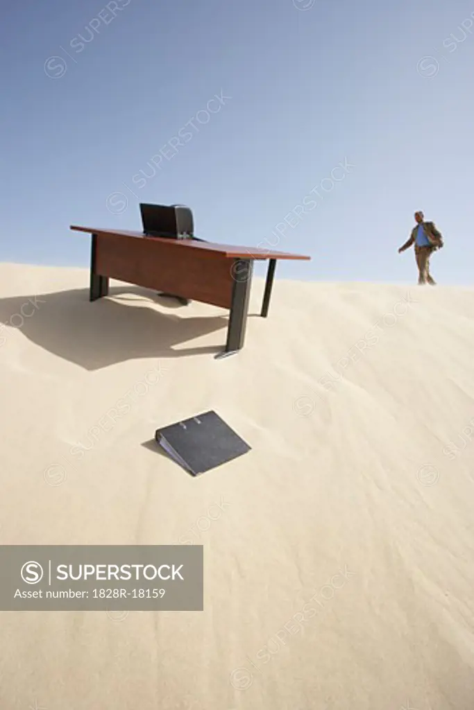 Businessman Approaching Desk in Desert   