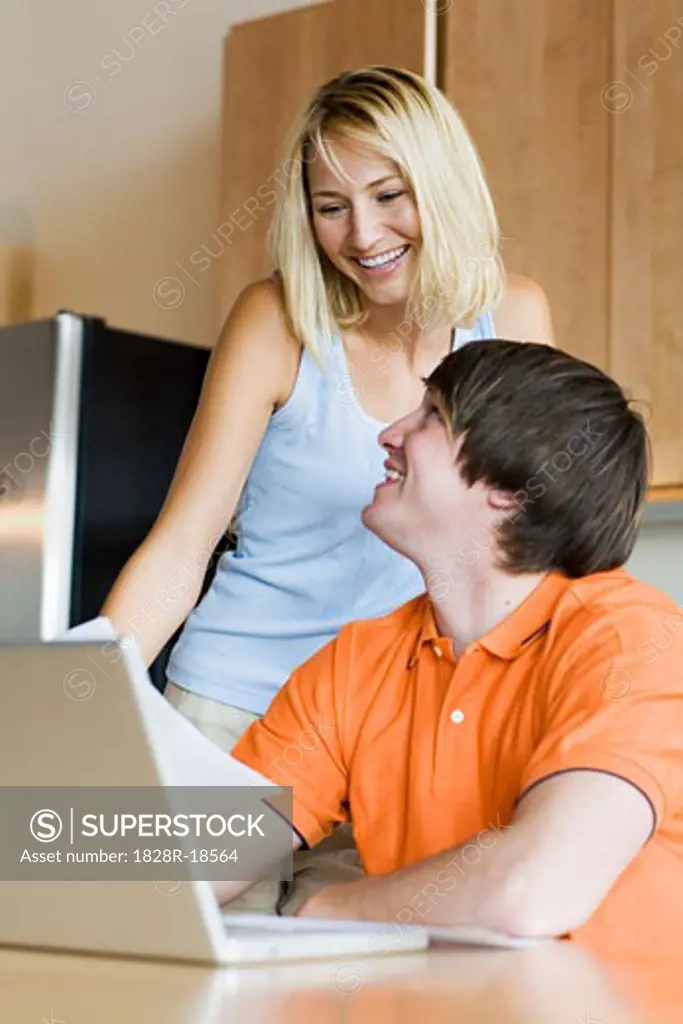 Couple in Kitchen with Laptop Computer   