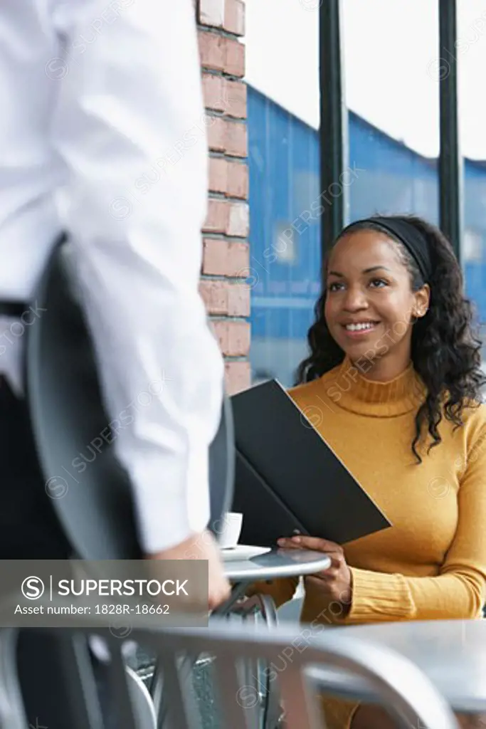 Woman Talking to Waiter at Cafe   