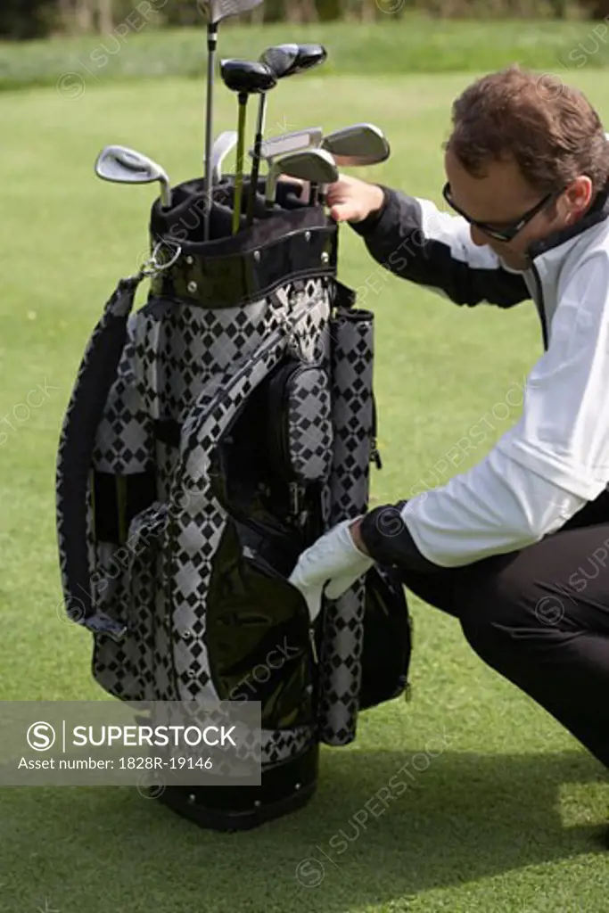 Man Looking at Golf Bag   