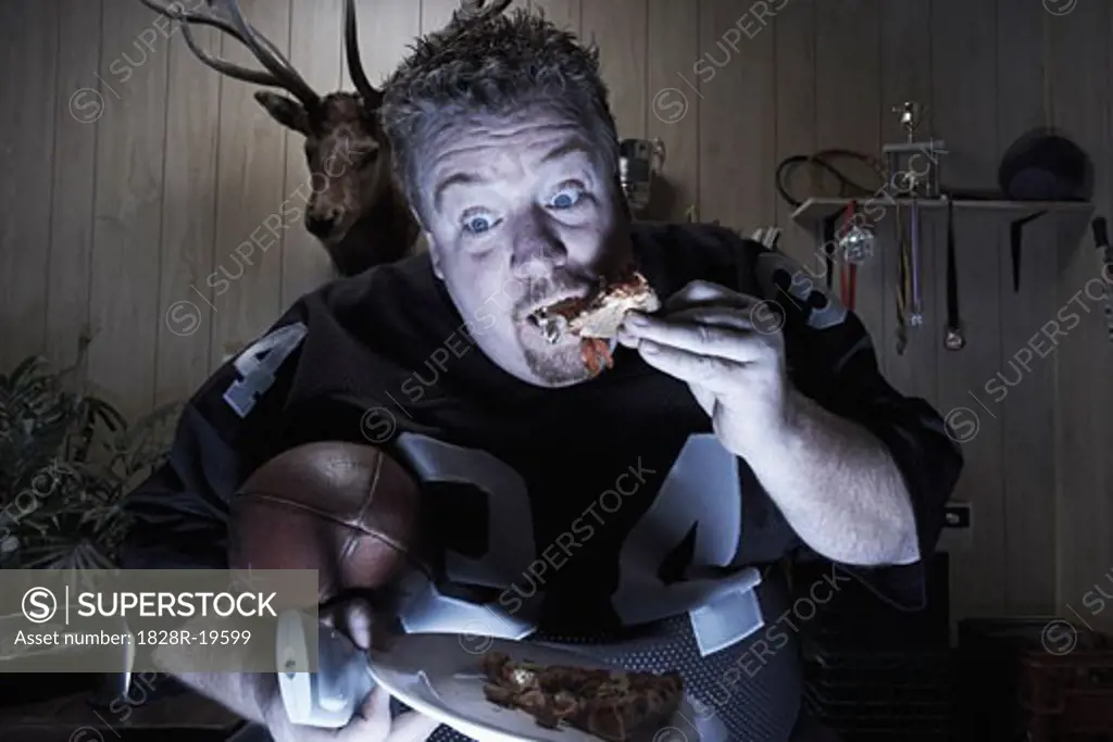 Man Watching TV and Eating Pizza   