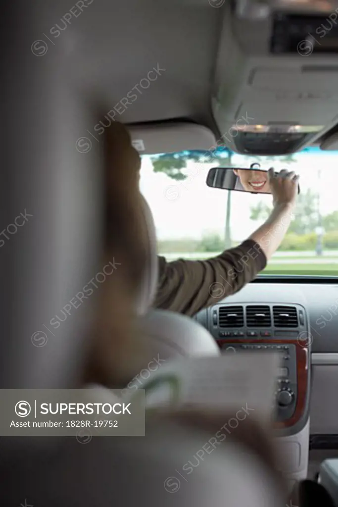 Mother Looking Back at her Son in Rear-View Mirror   