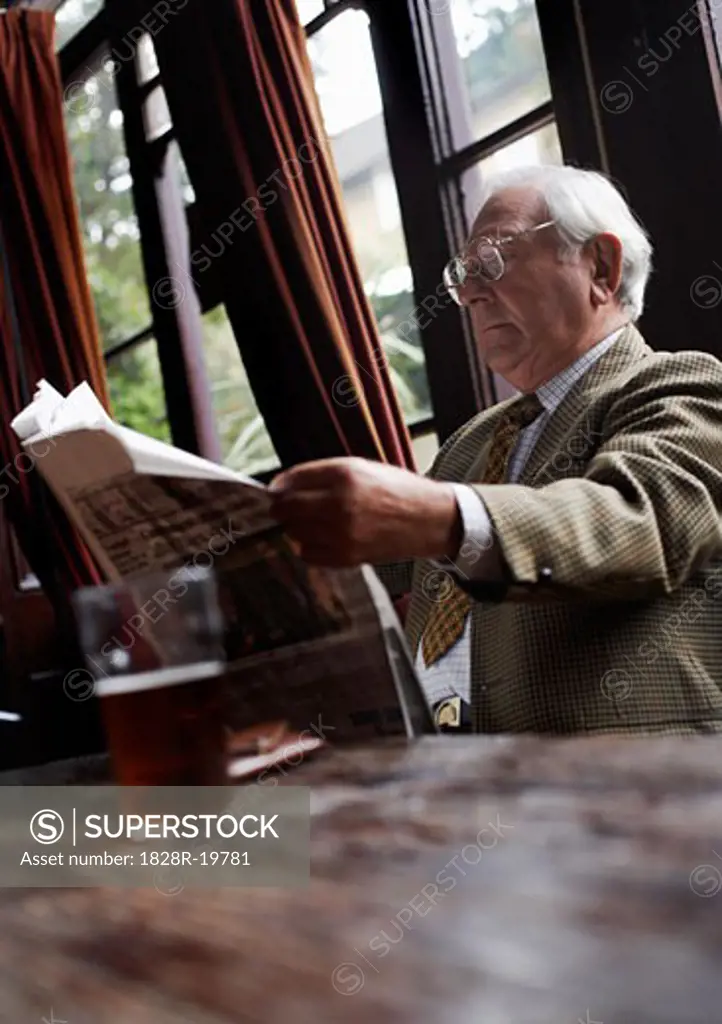 Man Reading Newspaper in Pub   