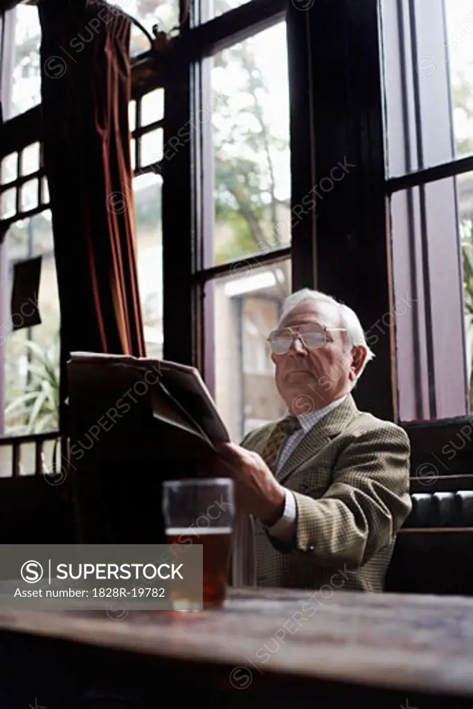 Man Reading Newspaper in Pub   