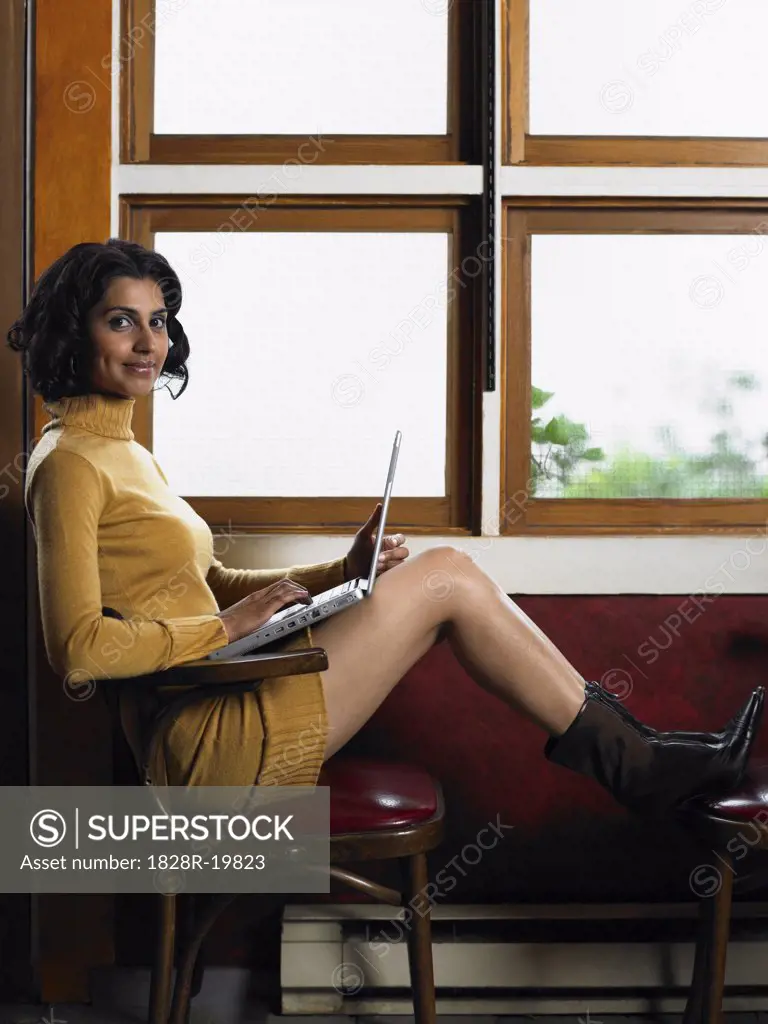Woman by Window with Laptop Computer   