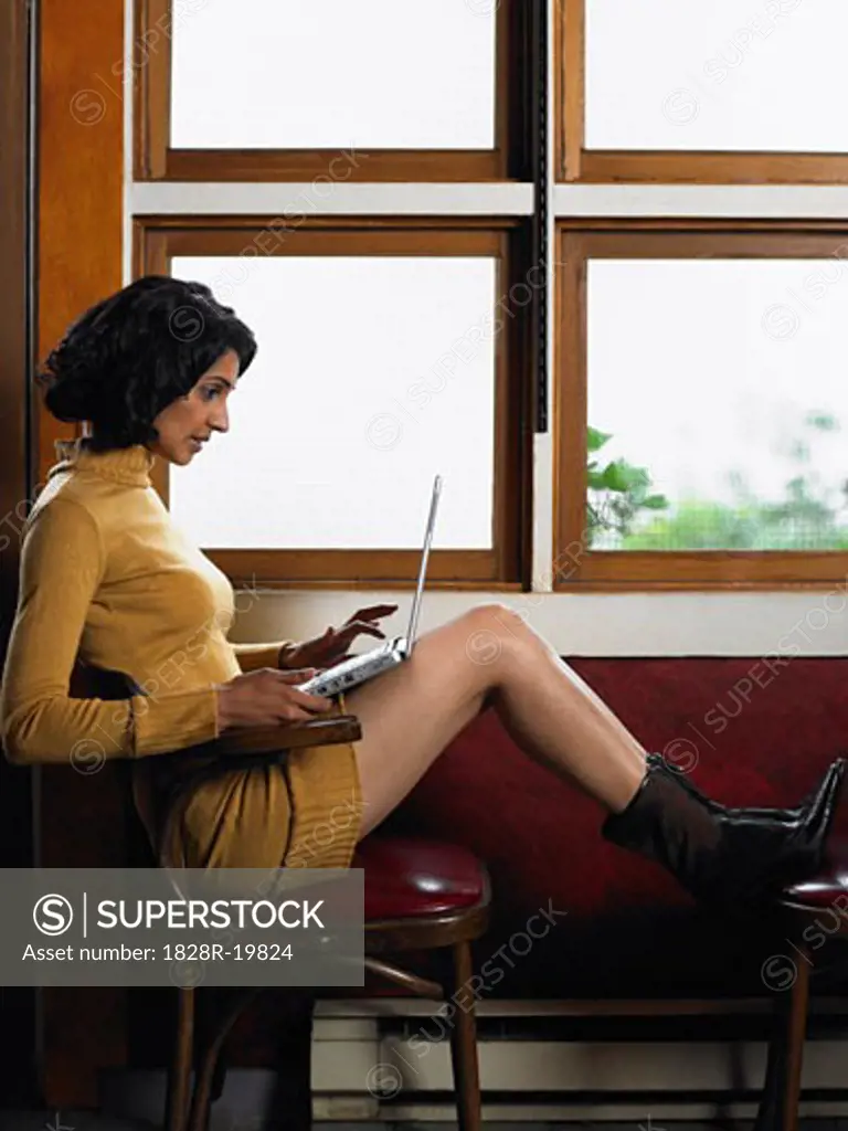Woman by Window with Laptop Computer   