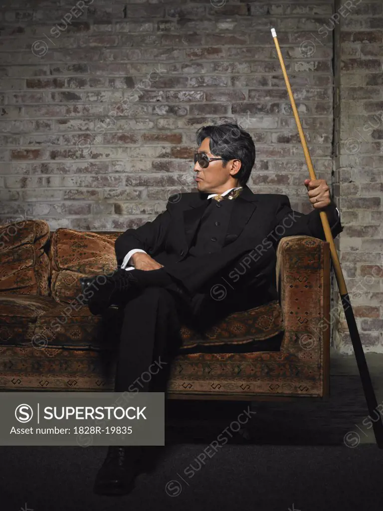 Portrait of Man on Sofa with Pool Cue   