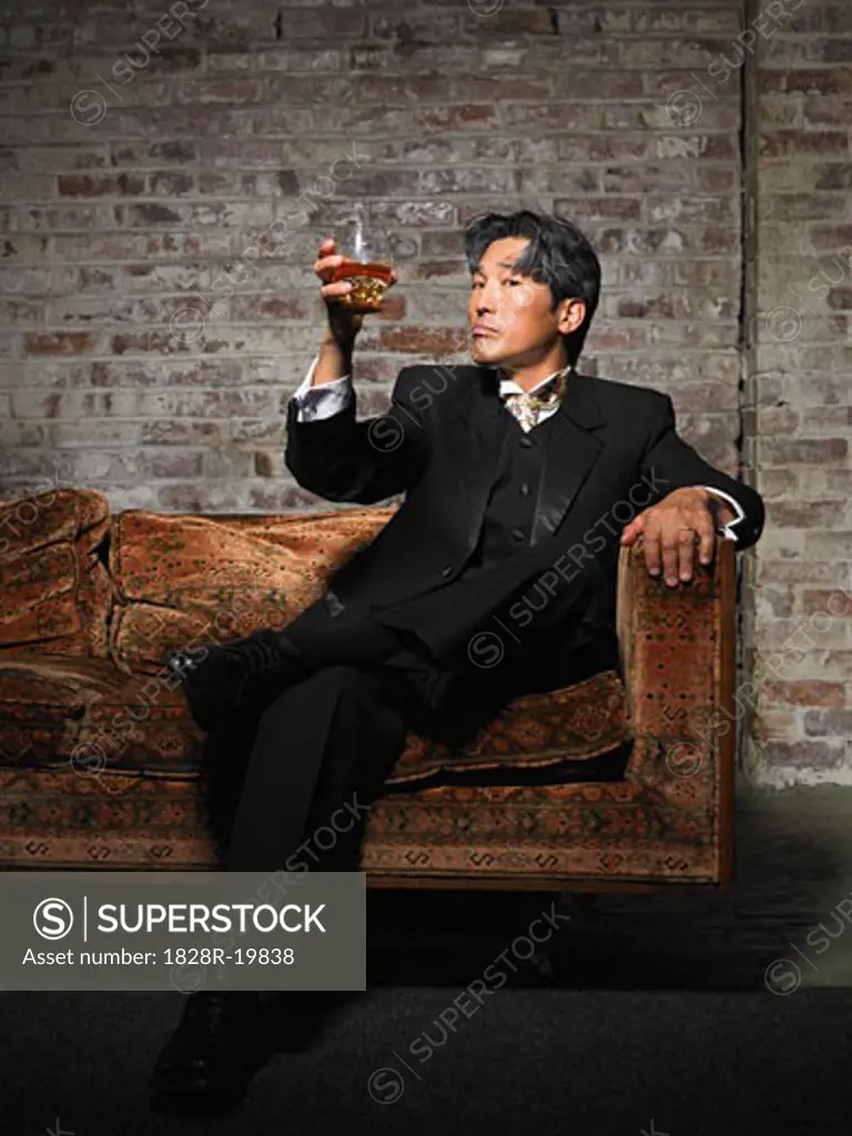 Portrait of Man on Sofa with Glass of Liquor   
