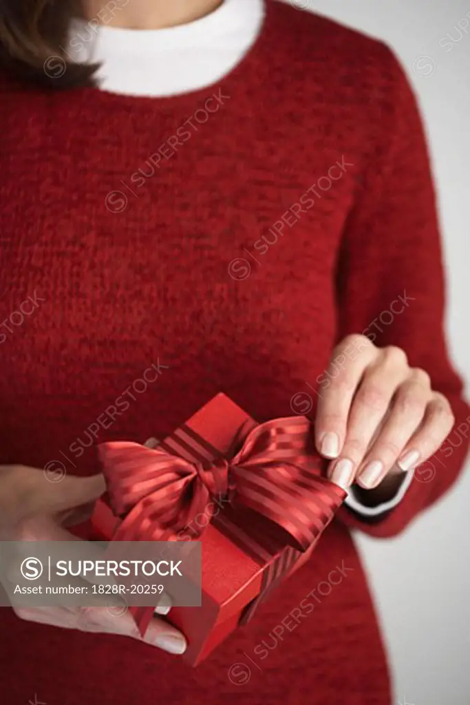 Woman Adjusting Bow on Gift   