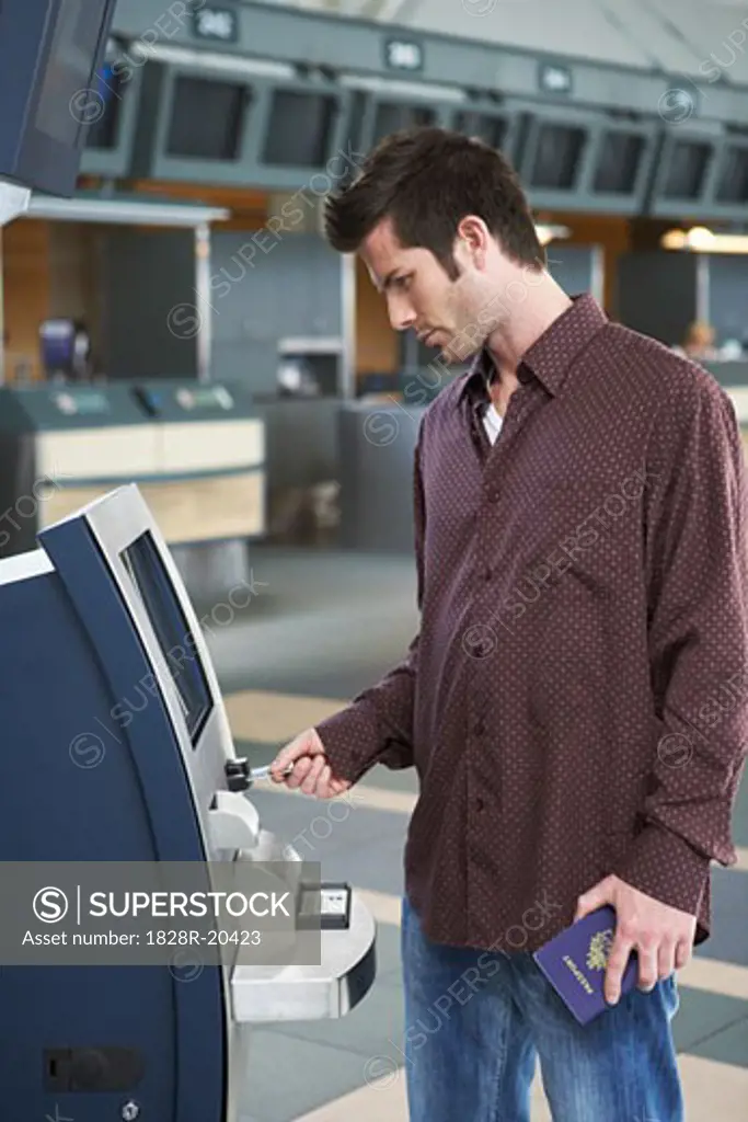 Man Using Ticket Machine in Airport