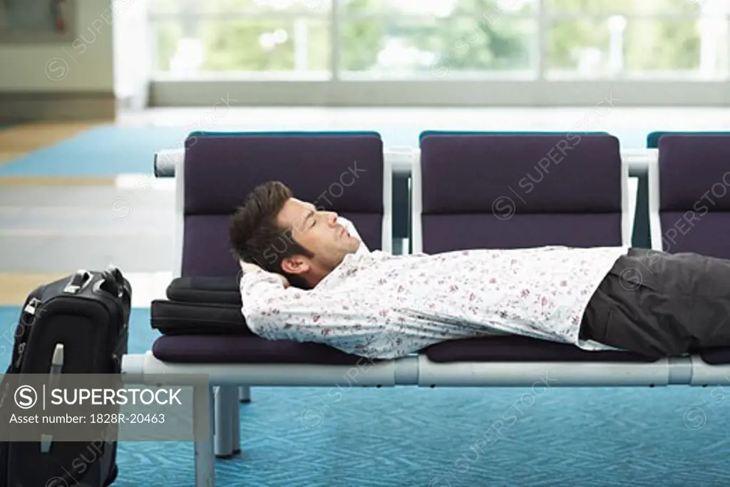 Man Sleeping in Airport Waiting Area   
