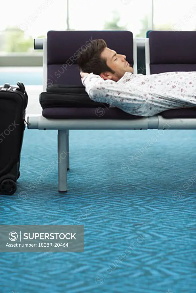 Man Sleeping in Airport Waiting Area   