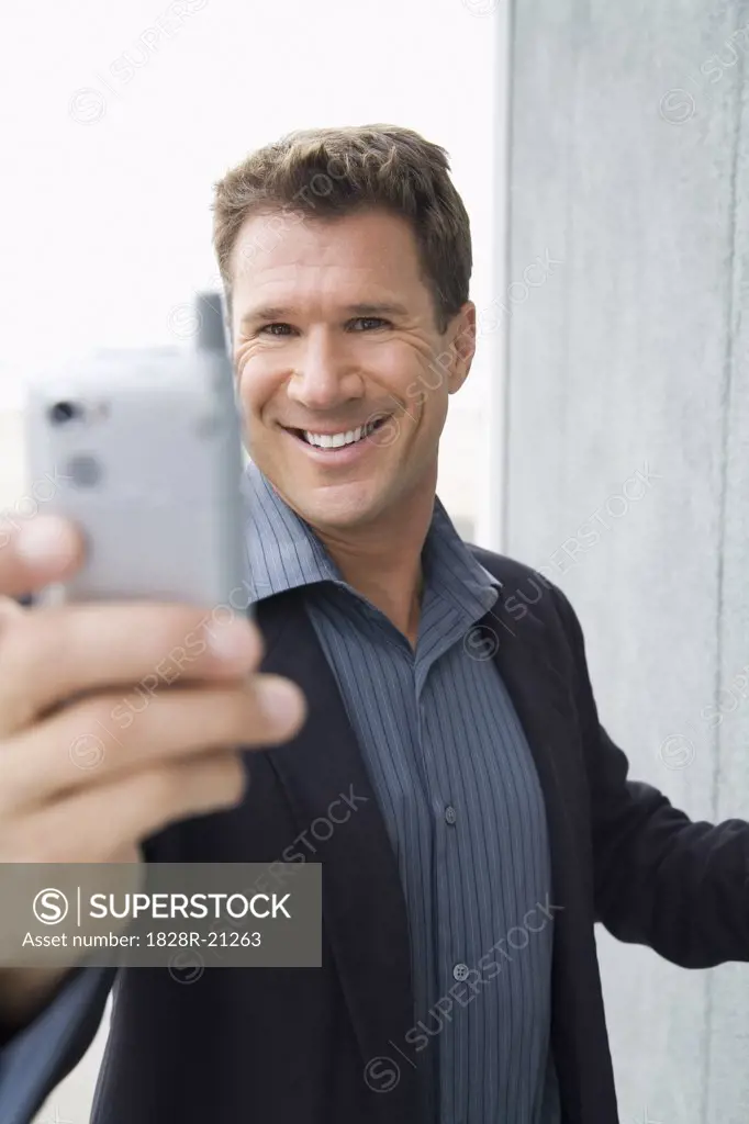 Businessman Taking Photo with Camera Phone   