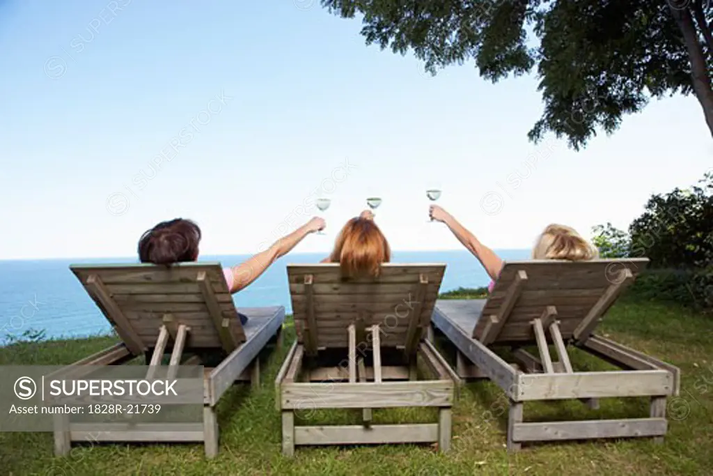 Women Sitting Outdoors and Drinking Wine   