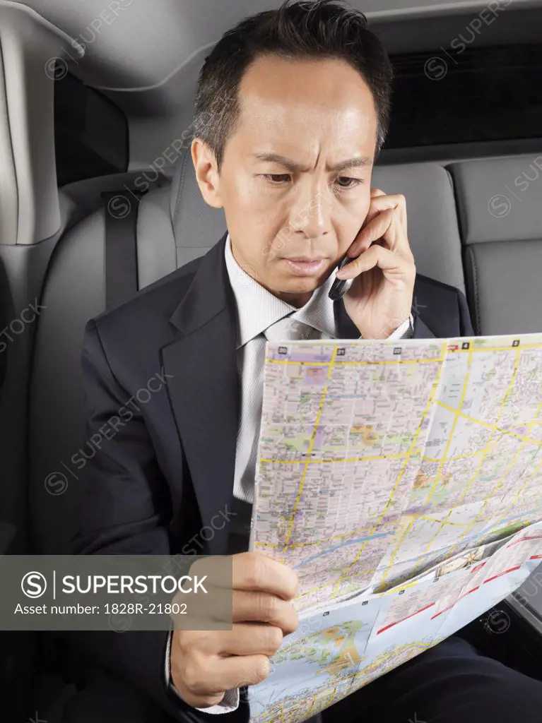 Businessman Looking at Map in Car   