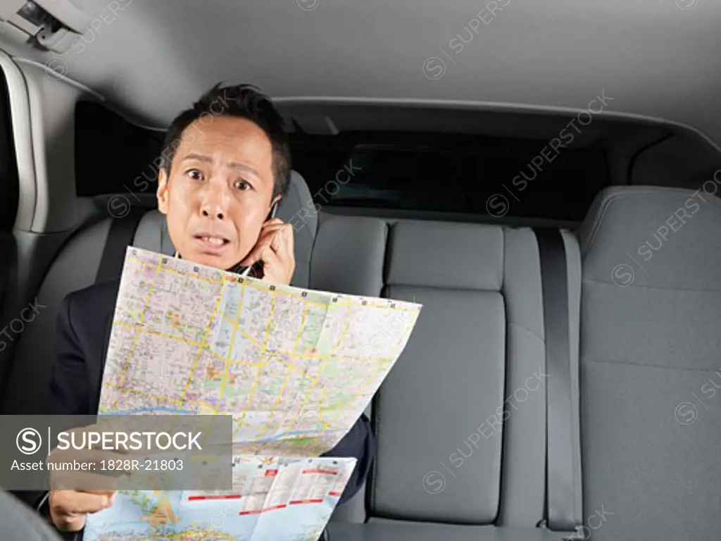 Businessman Looking at Map in Car   