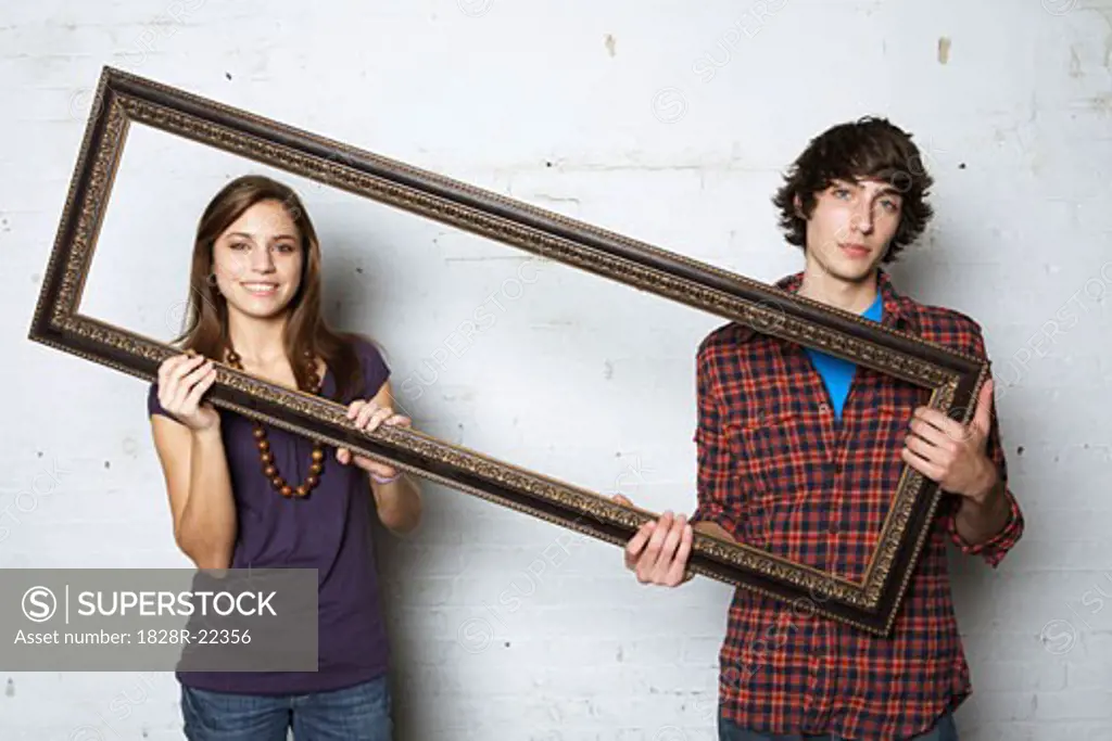 Young Couple Holding Picture Frame   