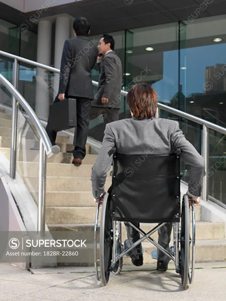 Man in Wheelchair Looking at Staircase   