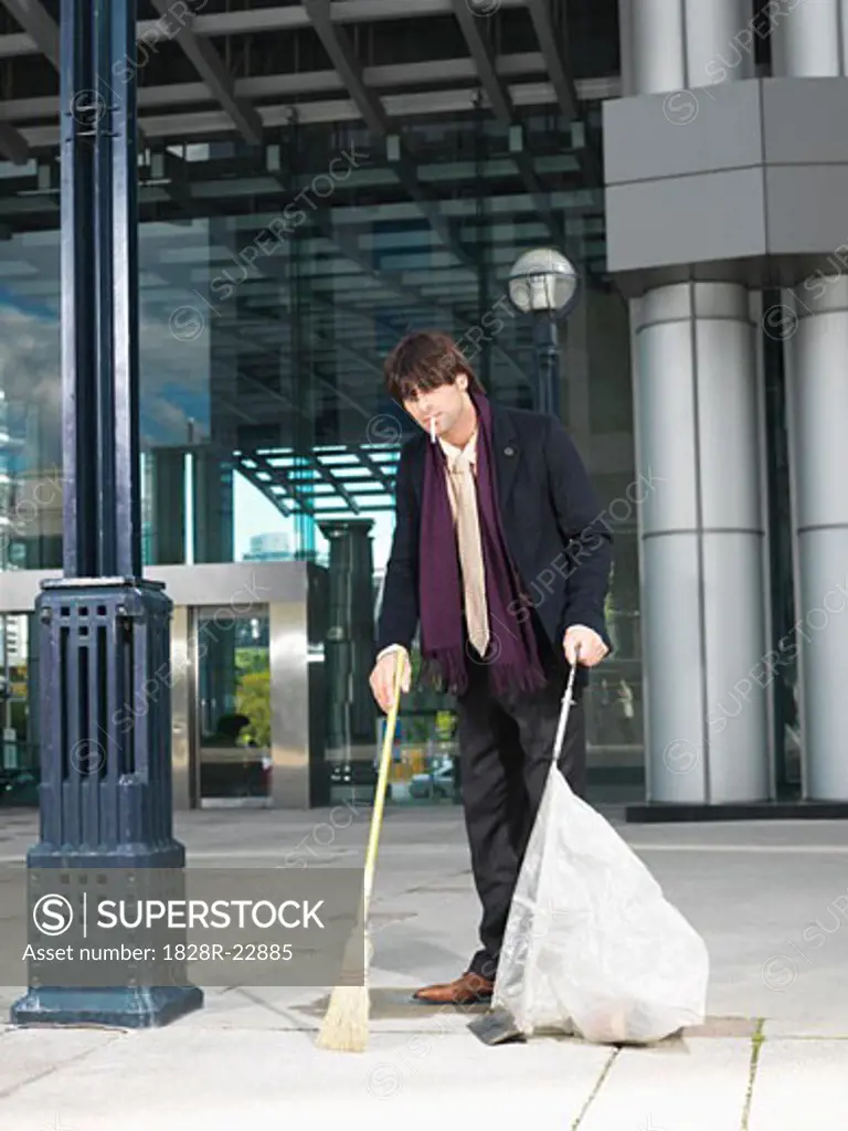 Man Sweeping Up Outside Building   