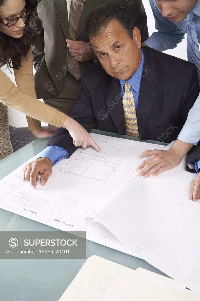 Business People Looking at Blueprints   