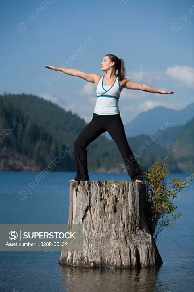 Woman Doing Yoga on Tree Stump   