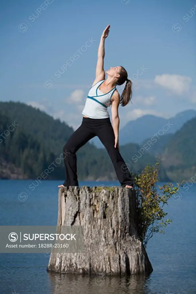 Woman Doing Yoga on Tree Stump   