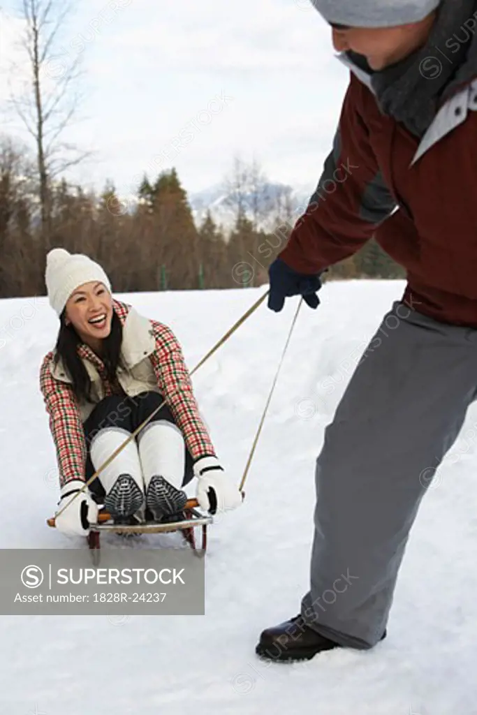 Man Pulling Woman on Sled, Whistler, British Columbia, Canada   