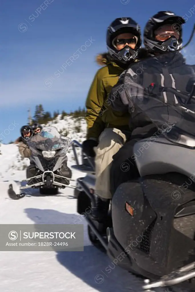 People Snowmobiling   