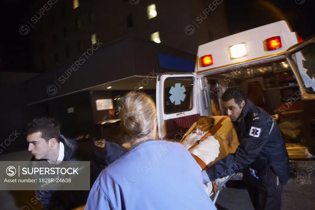 Doctor and Paramedics Removing Patient from Ambulance   